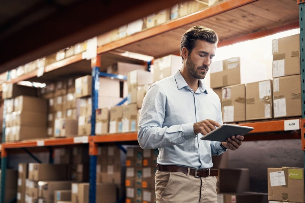 Shot of a young man using a digital tablet while working in a warehouse