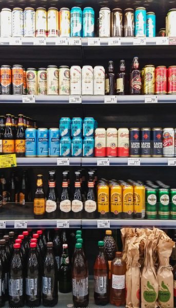 Beer in bottles and cans on grocery store shelves