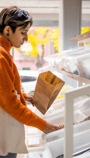 Young woman buying healthy ingredients at local shop